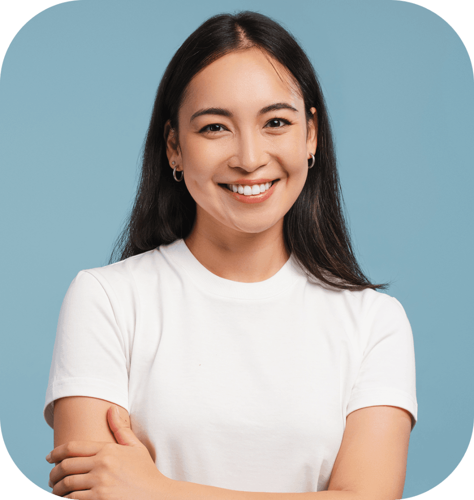 Portrait of a smiling woman with shoulder-length dark hair wearing a white t-shirt against a blue background, clean studio lighting, rounded photo corners